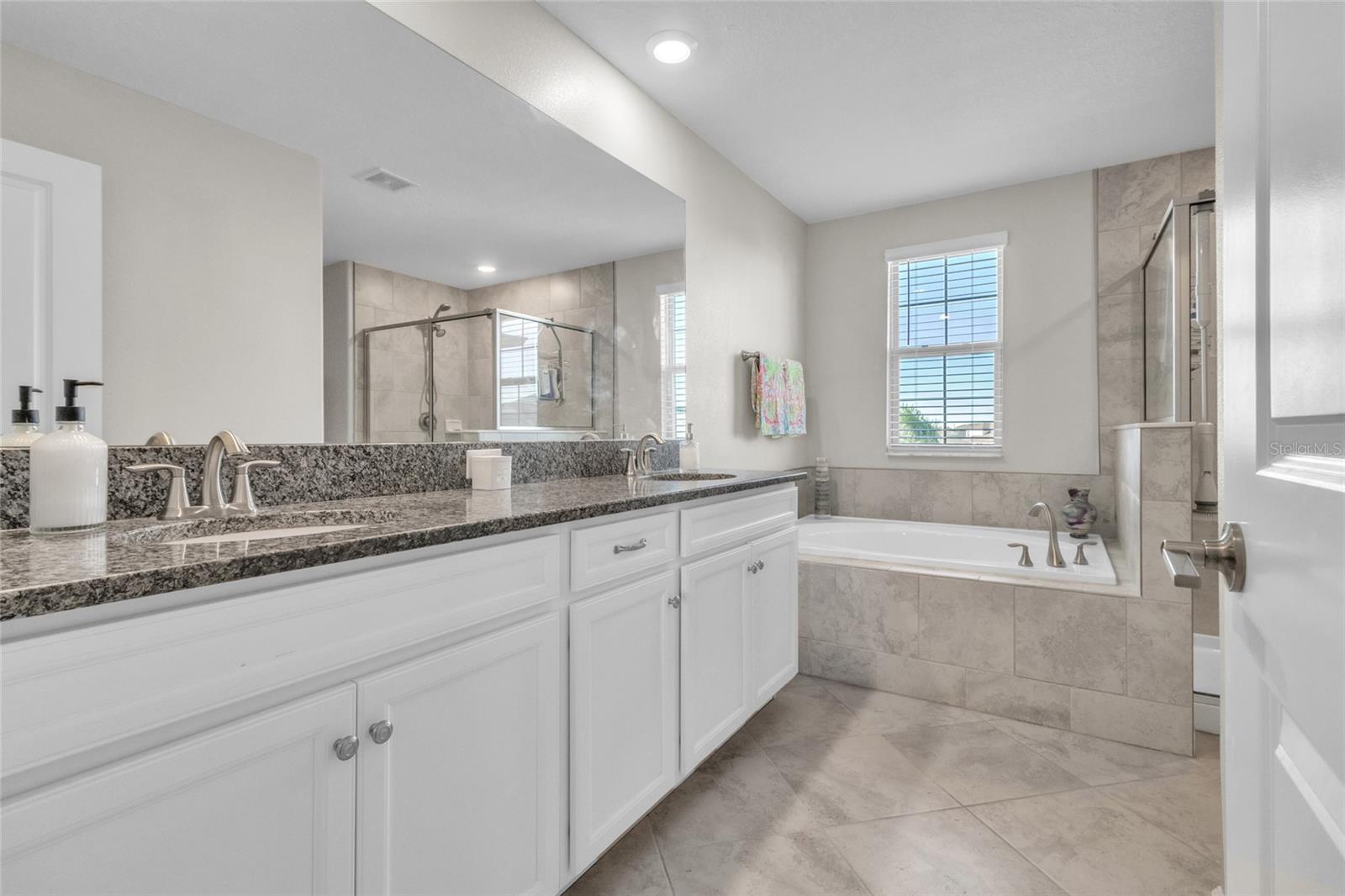 Owners suite bathroom features the tile on lower level for a nice cohesive tone. Granite counter tops in the bathrooms enhance the luxe sensation.