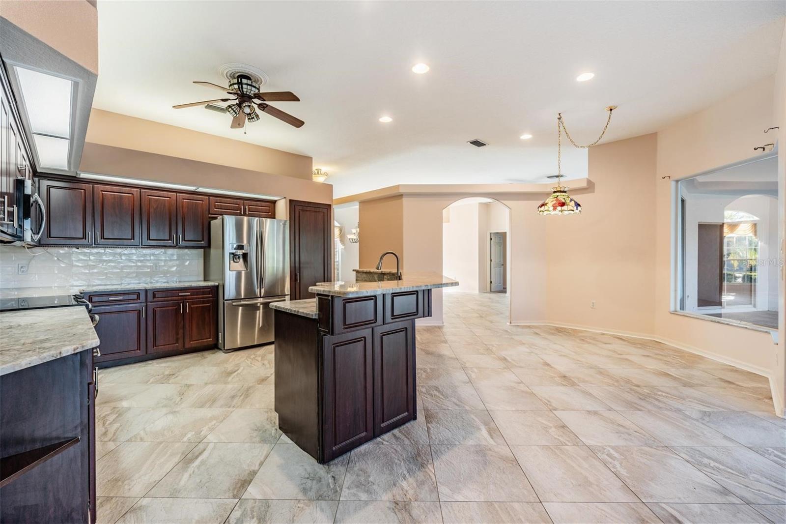 Oversized window in the family room/kitchen area views lanai and pool