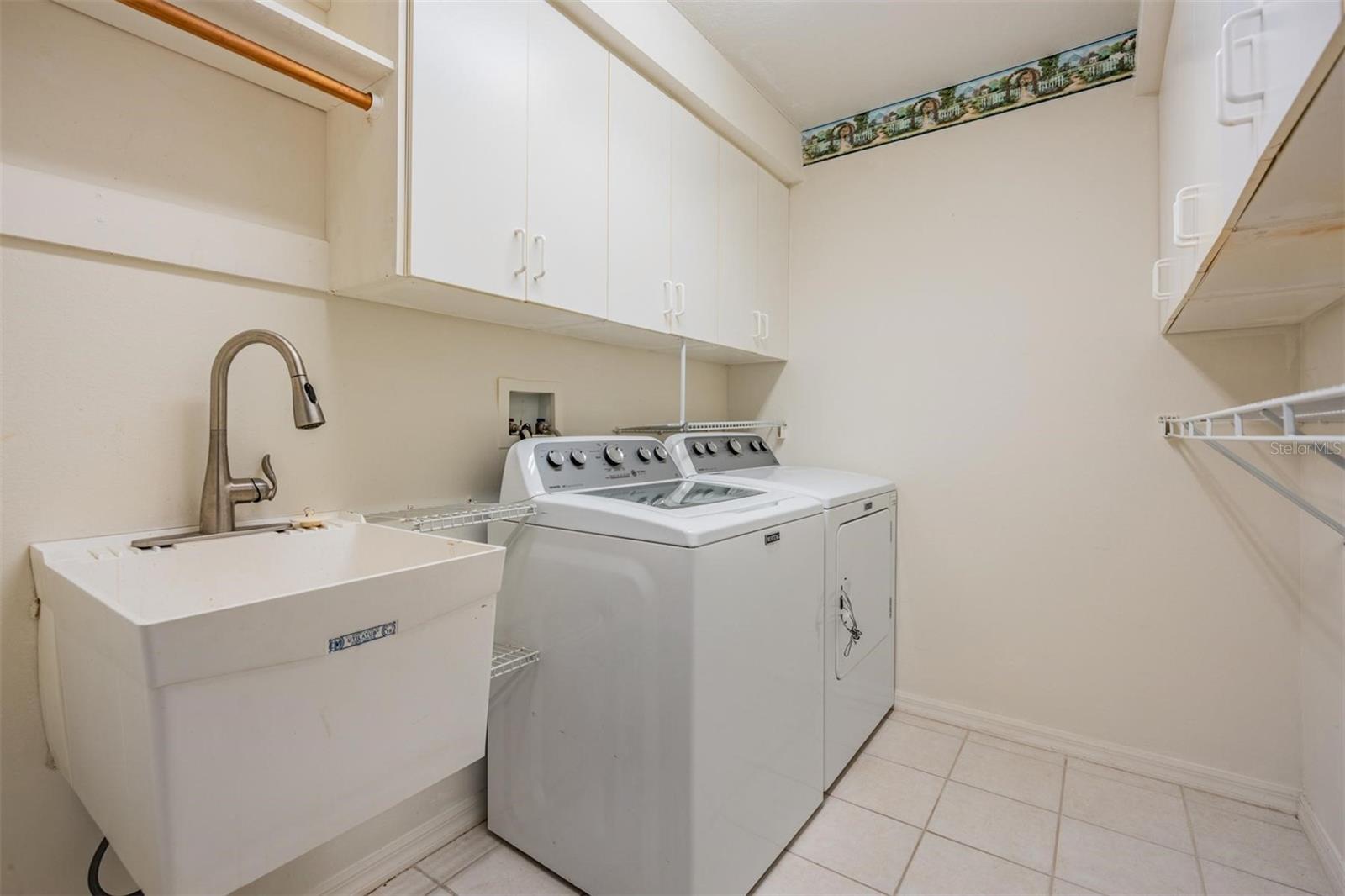 Walk-in laundry room with built-in storage and utility sink