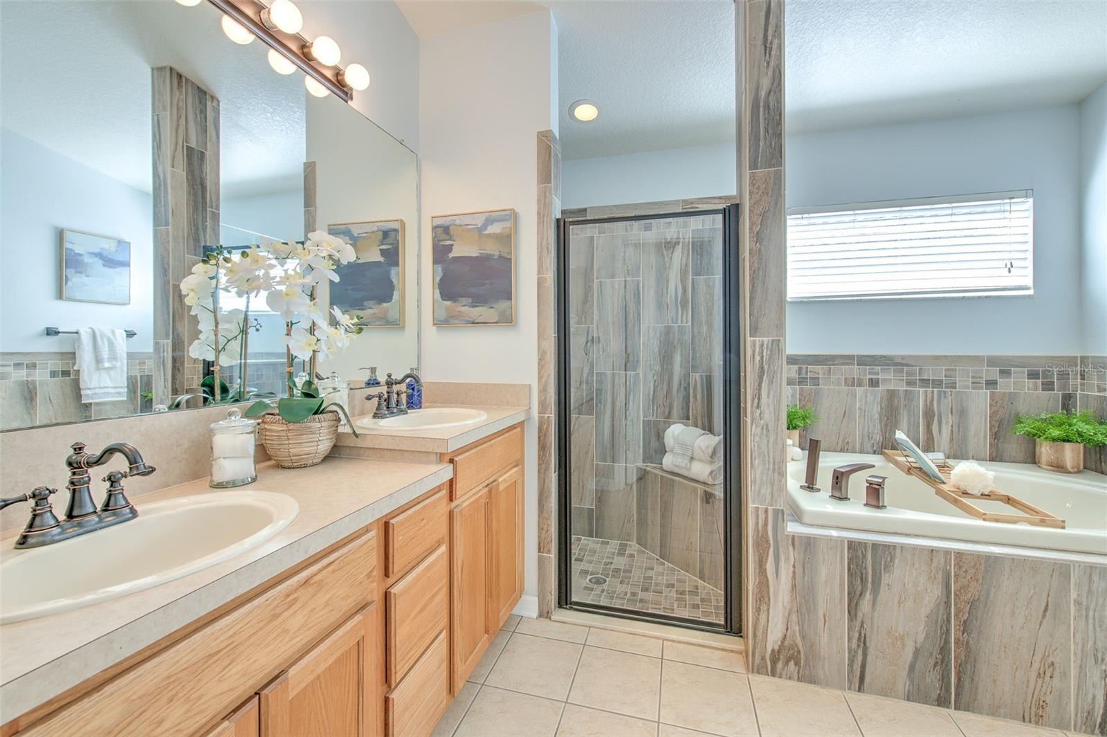 Spa-like primary bathroom with separate shower, soaking tub, and dual sinks