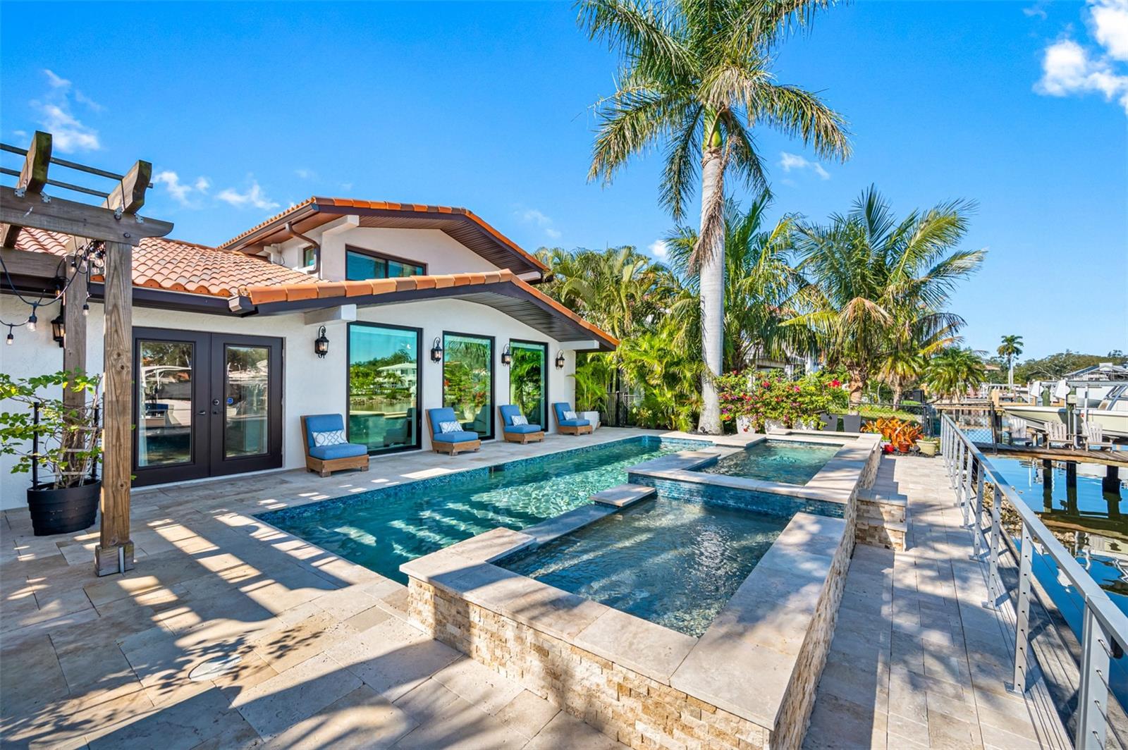 Beautifully landscaped pool area with travertine pavers