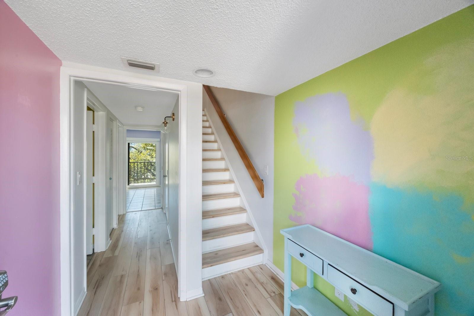 Charming, colorful entry with staircase to upstairs