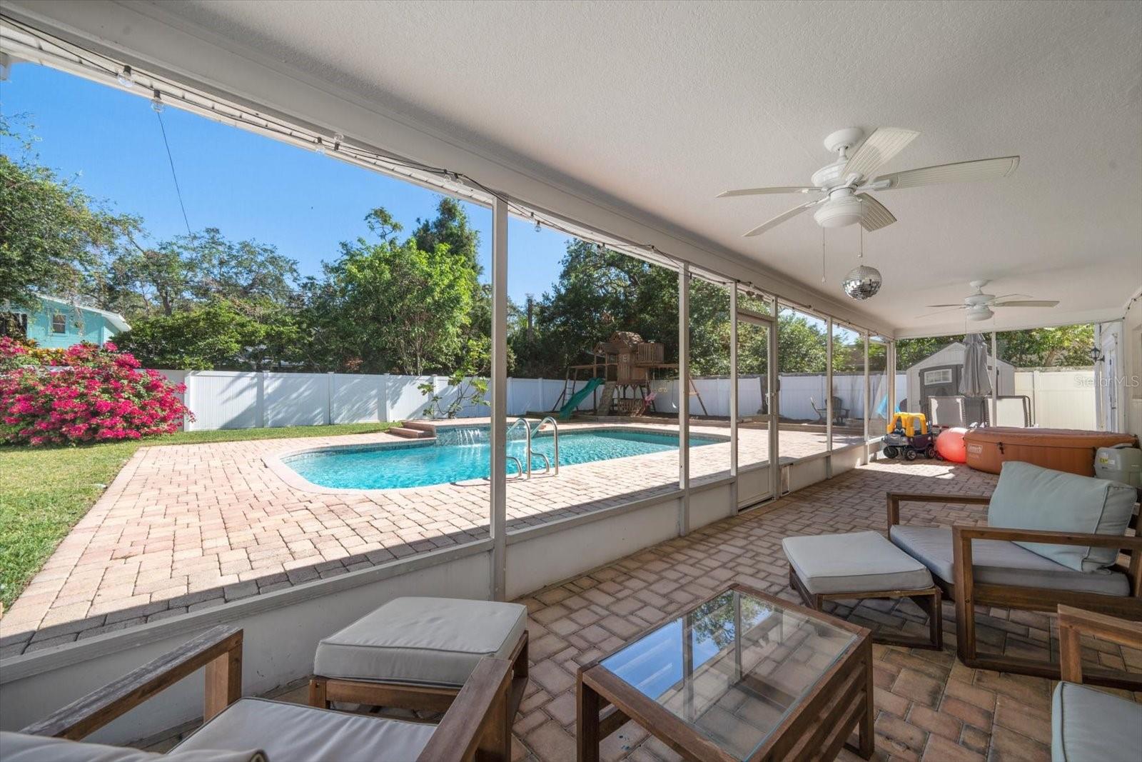 Relax in the screened porch area and enjoy the visuals of the lovely pool with waterfall feature.