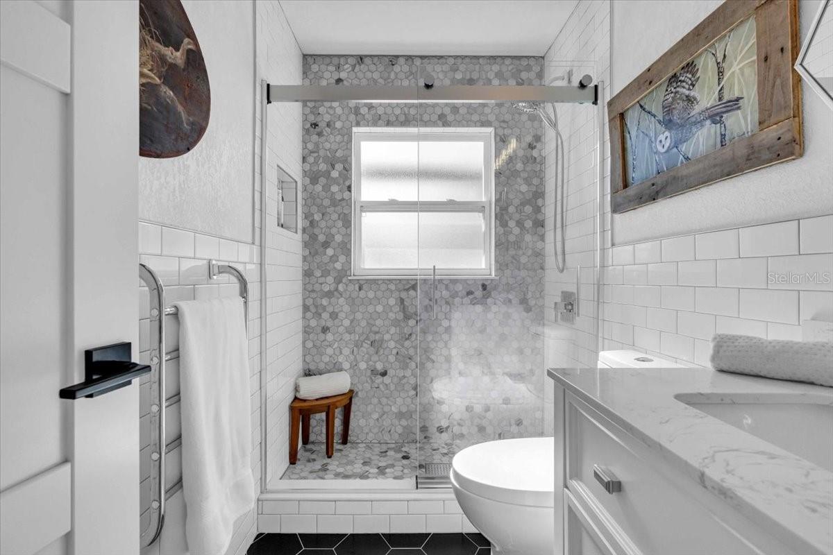 Well appointed bath with heated towel warmer, tiled to the ceiling