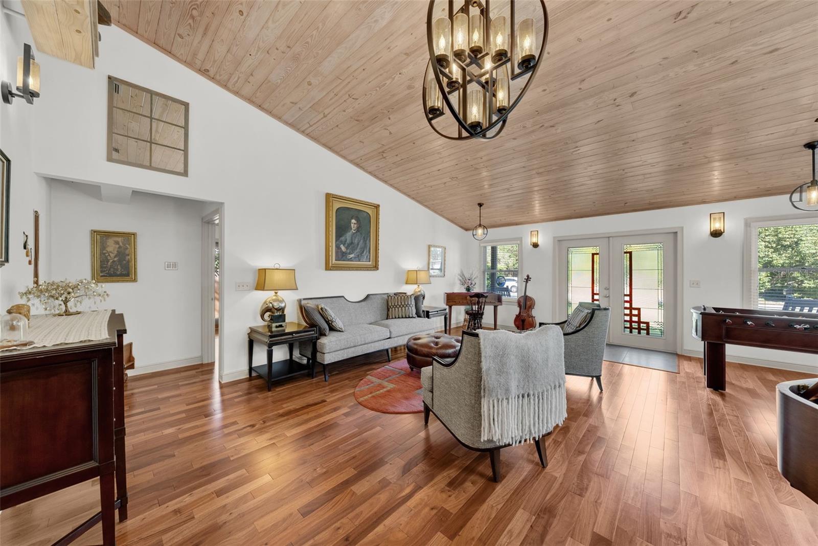 Vaulted ceiling covered in Knotty pine in main living room and engineered cherry hardwood flooring