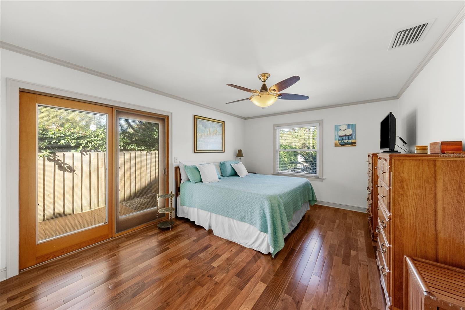 Primary bedroom with sliders to side yard and outdoor deck