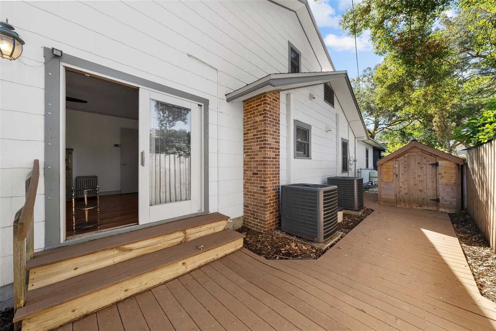 Side yard, deck with access to storage shed in back yard