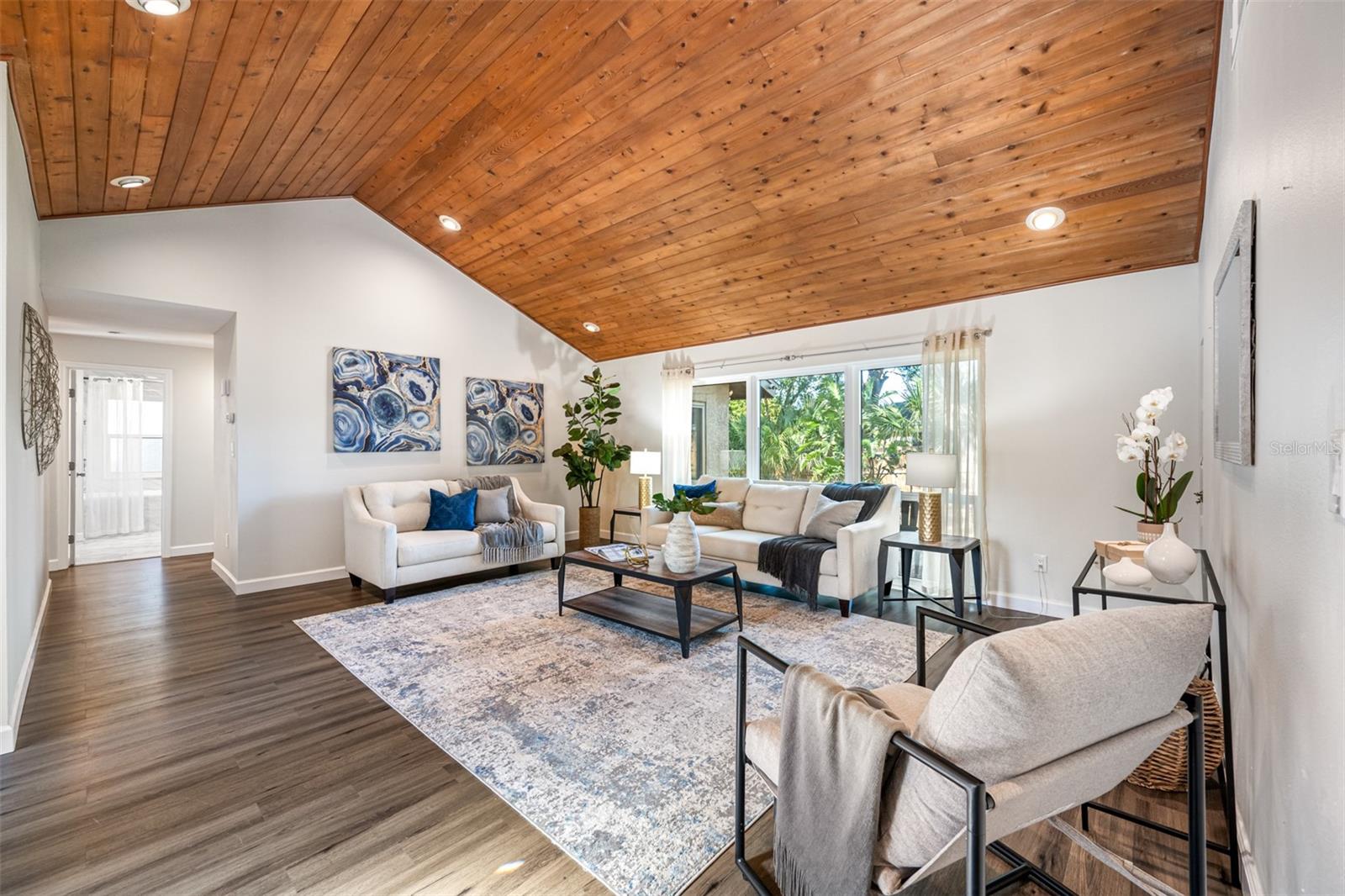 Spacious living room with tongue and groove plank vaulted ceiling