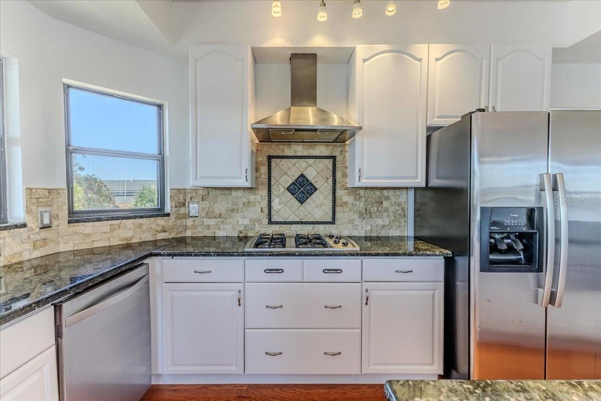 Gas Cooktop & Chimney Hood with Stone Backsplash