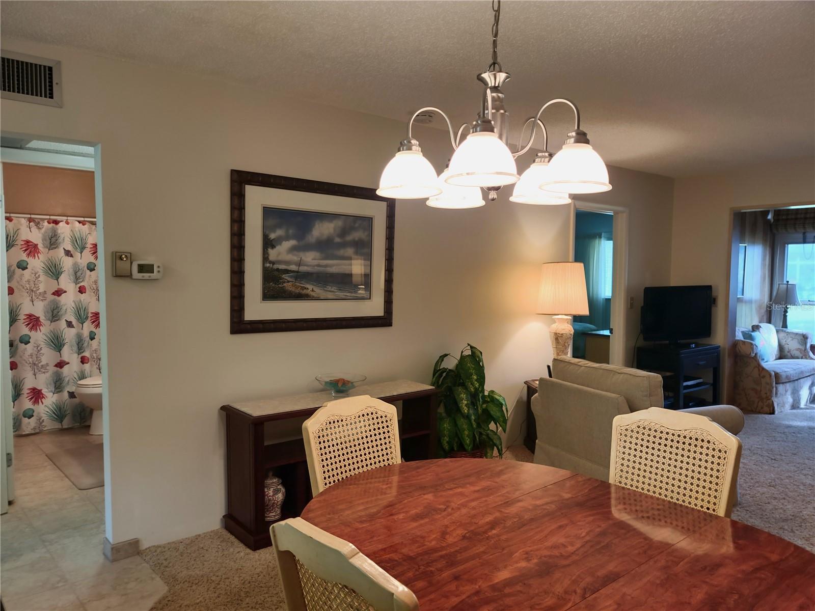 View of living area exiting guest bedroom/bath area.  Primary bedroom quarters entry to left of TV.