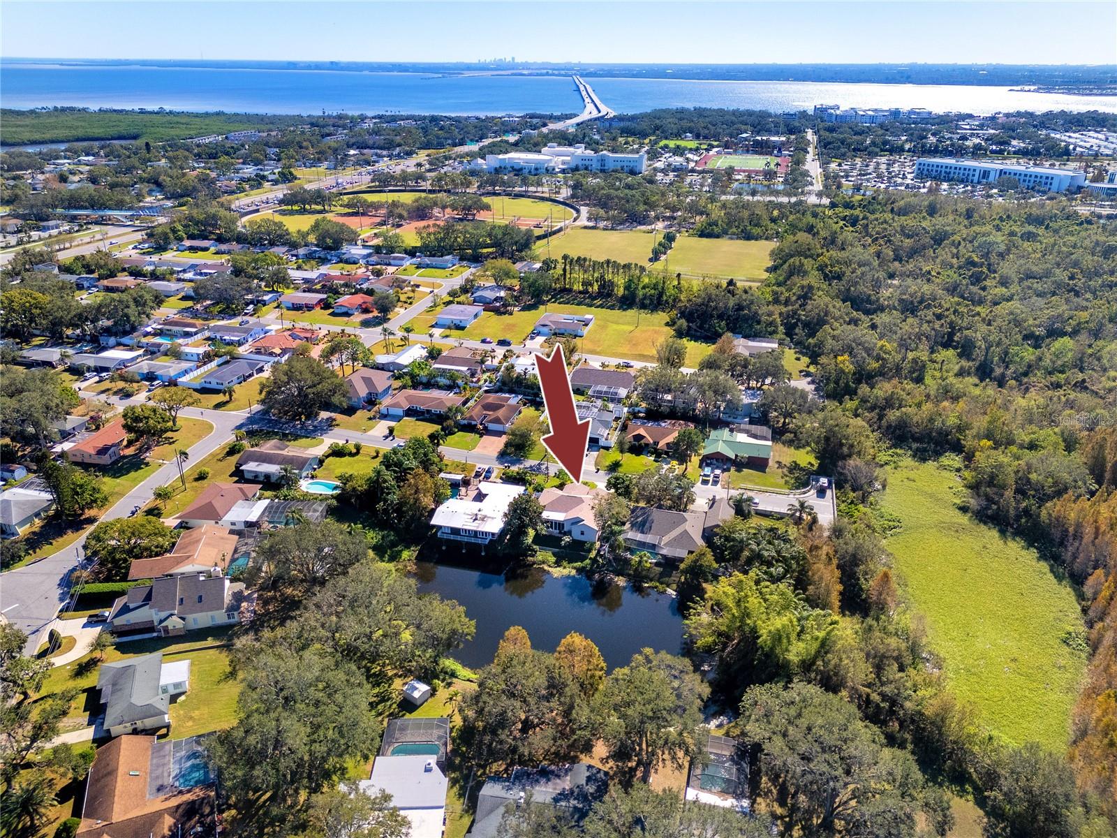 Aerial view of the house, the lake, Kapok Terrace Park, softball/soccer fields/Bayside Bridge and Tampa Bay