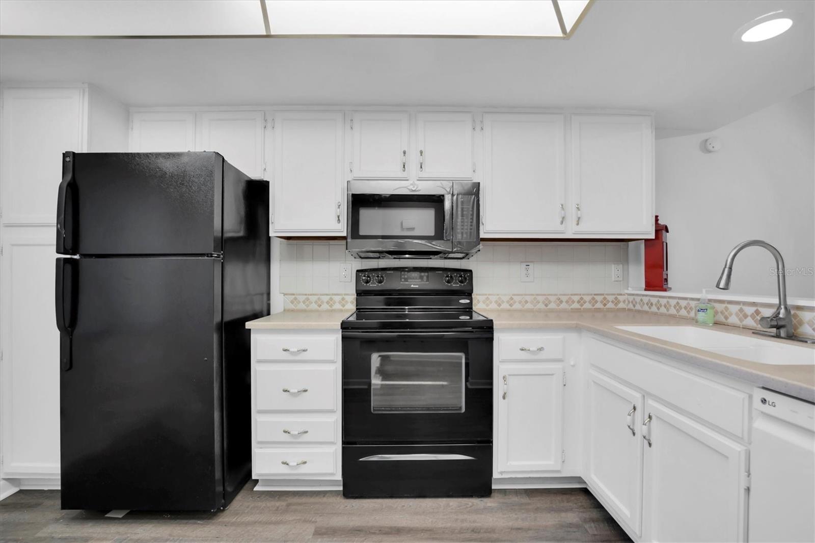 Clean, workable kitchen with nice counter space, new faucet. Extra cabinets on far side of refrigerator on left