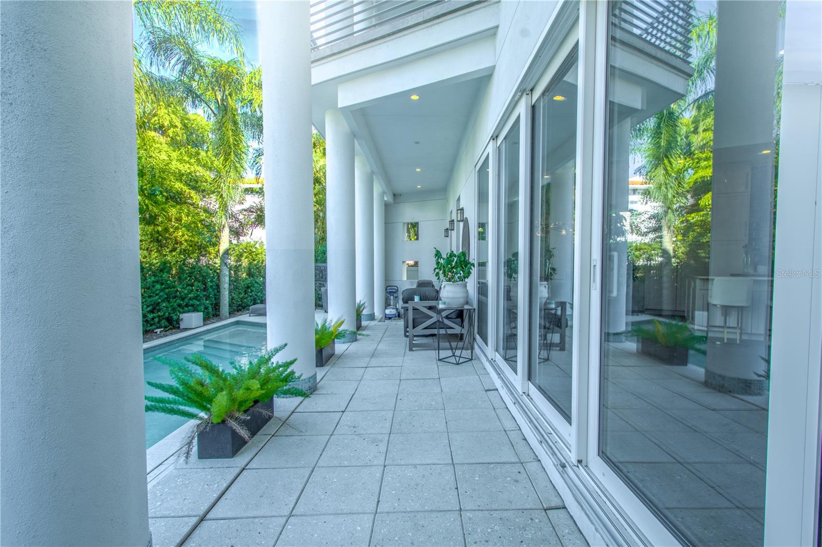 A stone tile patio cozies up to the saltwater pool and spa.