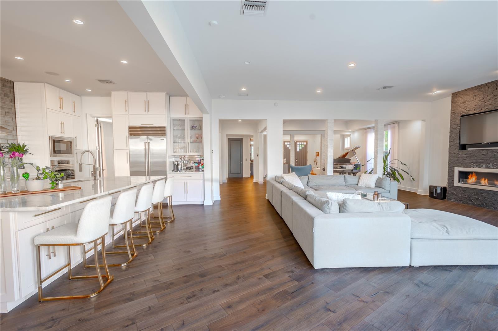 Effortless flow: the family room transitions seamlessly into the kitchen, highlighted by rich wood floors and neutral tones.