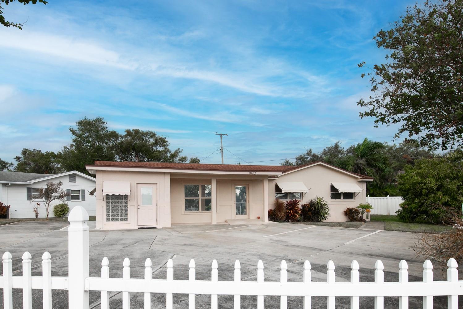 Front view of the building. Left hand side is the office space and the home on the right side. There is about 8 parking spaces.