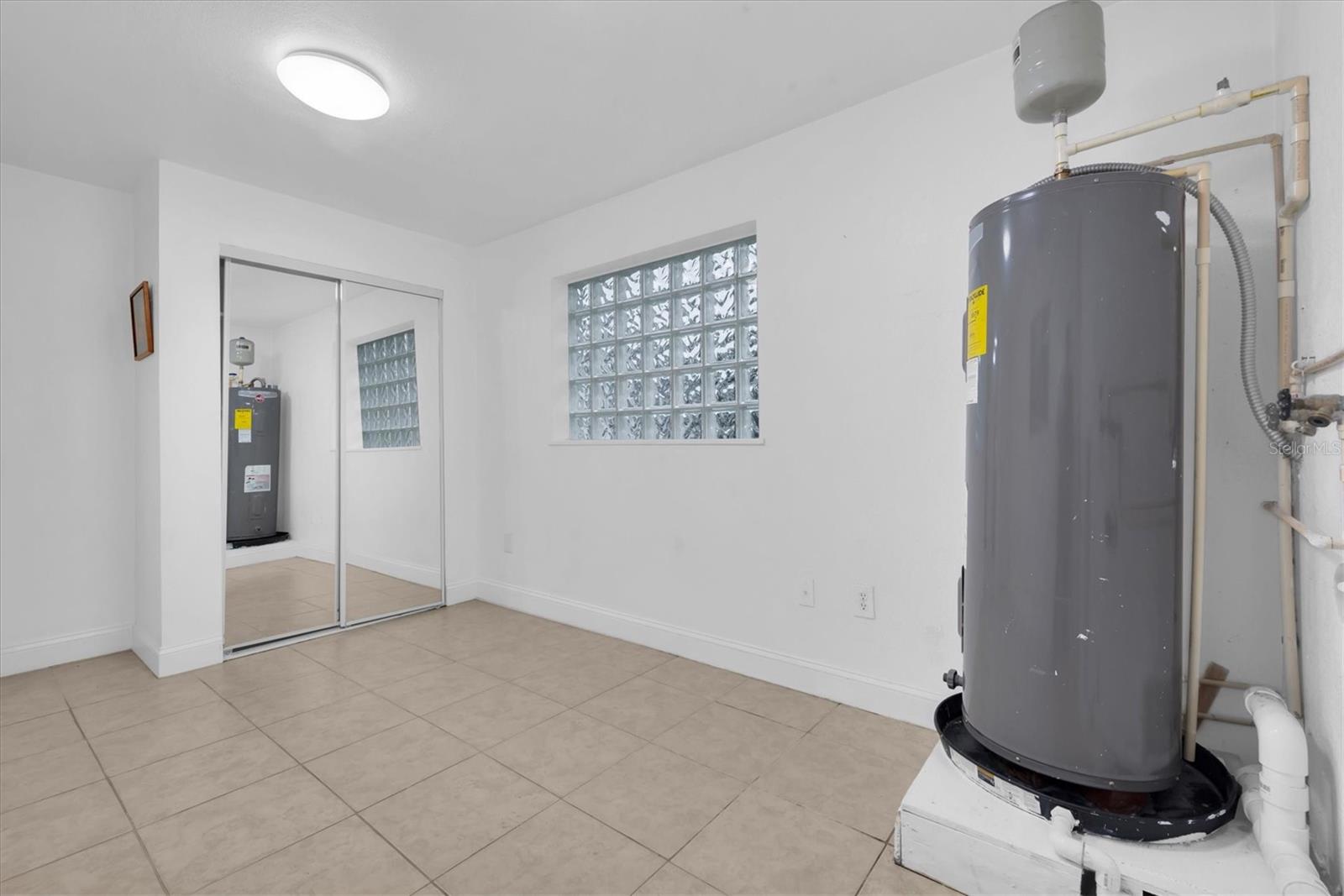 Utility room with washer dryer hook up and large closet for storage.