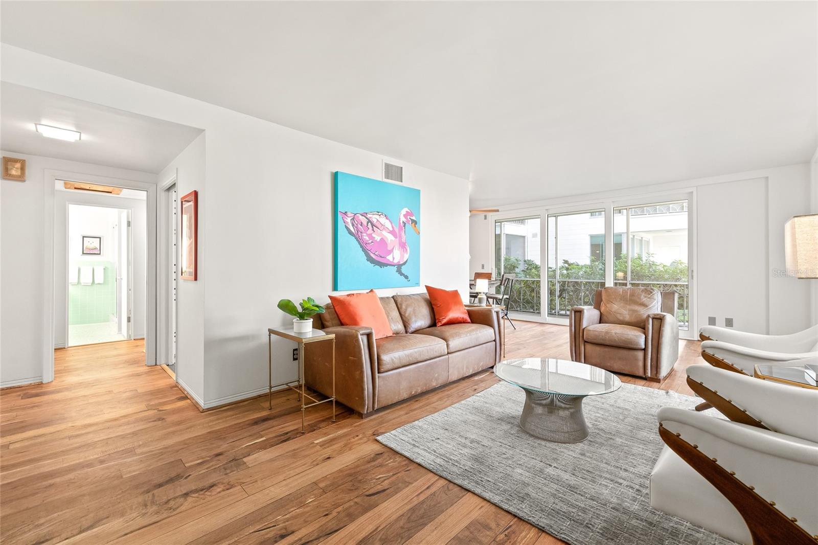 The opening to the left is the bathroom, and a hallway leads to the bedroom. To the right is the combo dining/ living space, and you can see the sliding doors that lead to the patio.