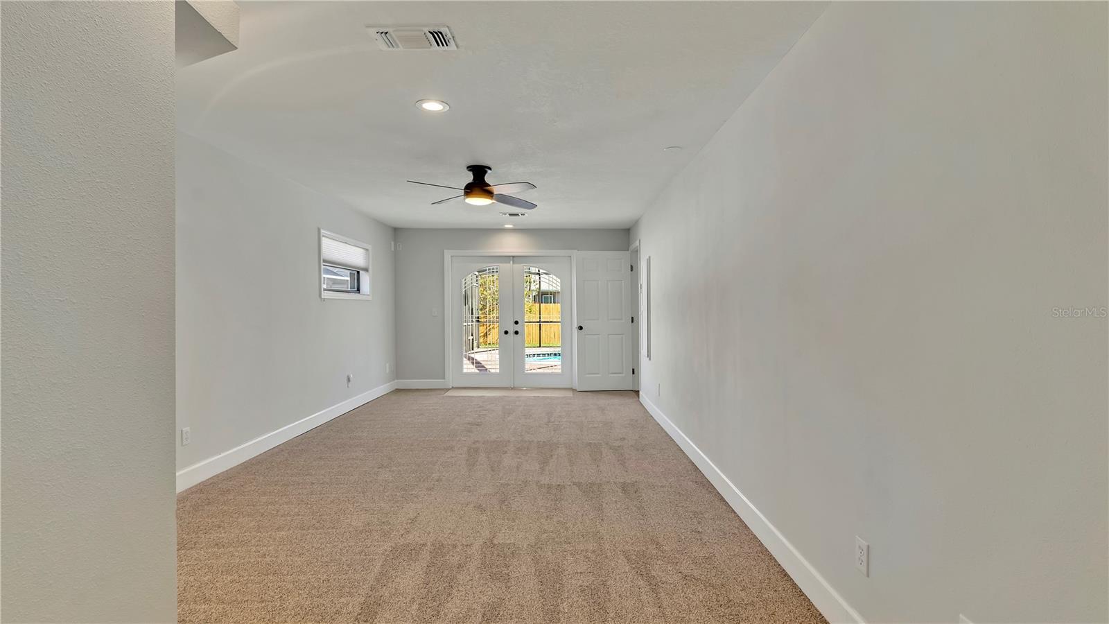 Primary Bedroom (12x26) looking towards the French Doors going to the screened in pool area