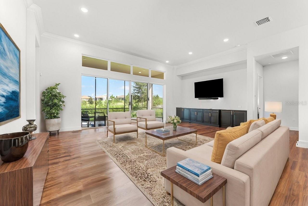 Living Room With High Ceilings, Recessed Lighting, Crown Molding & Built In Matching Cabinets