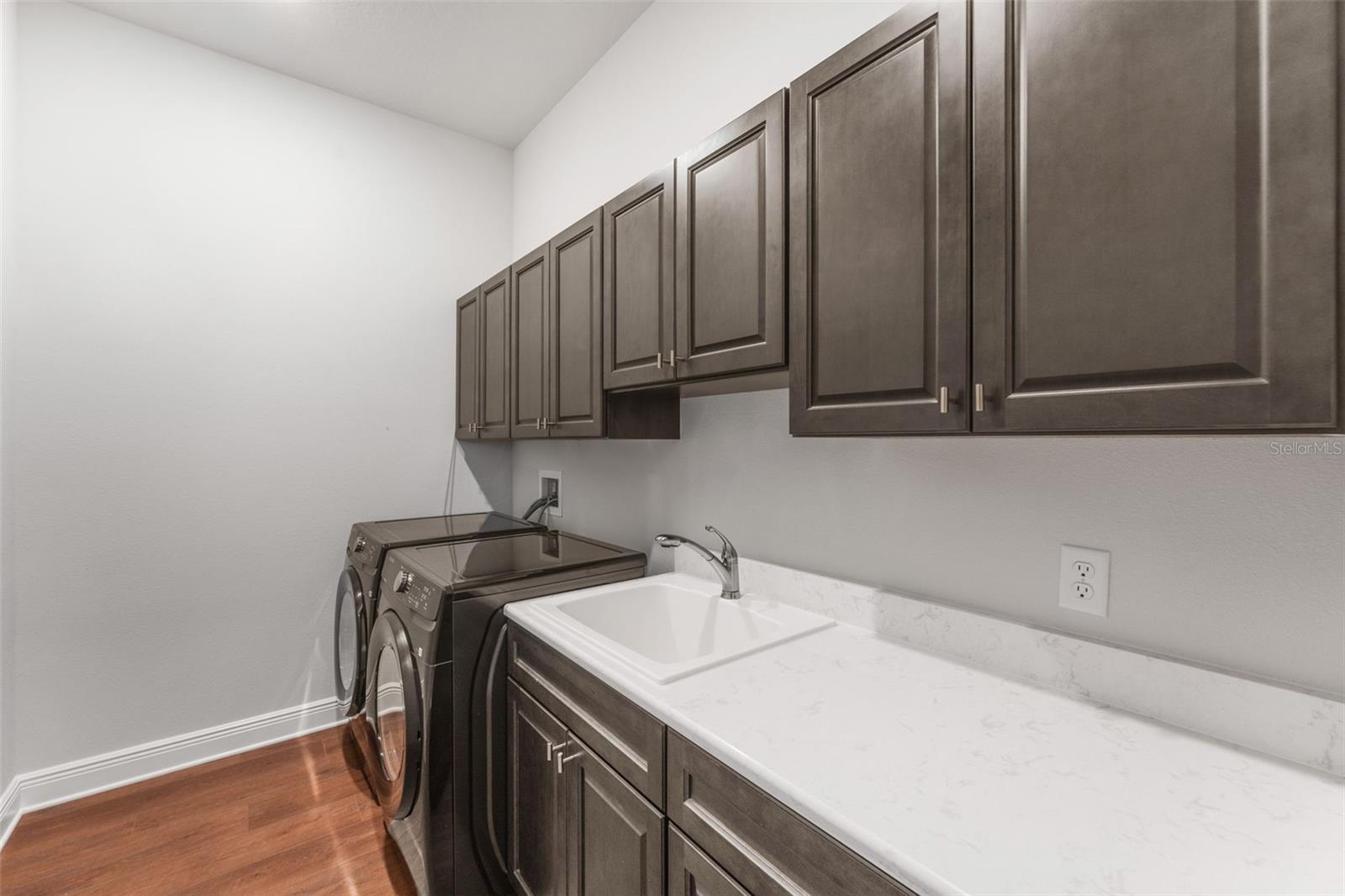 Matching Cabinets and Quartz Countertops With Laundry Sink