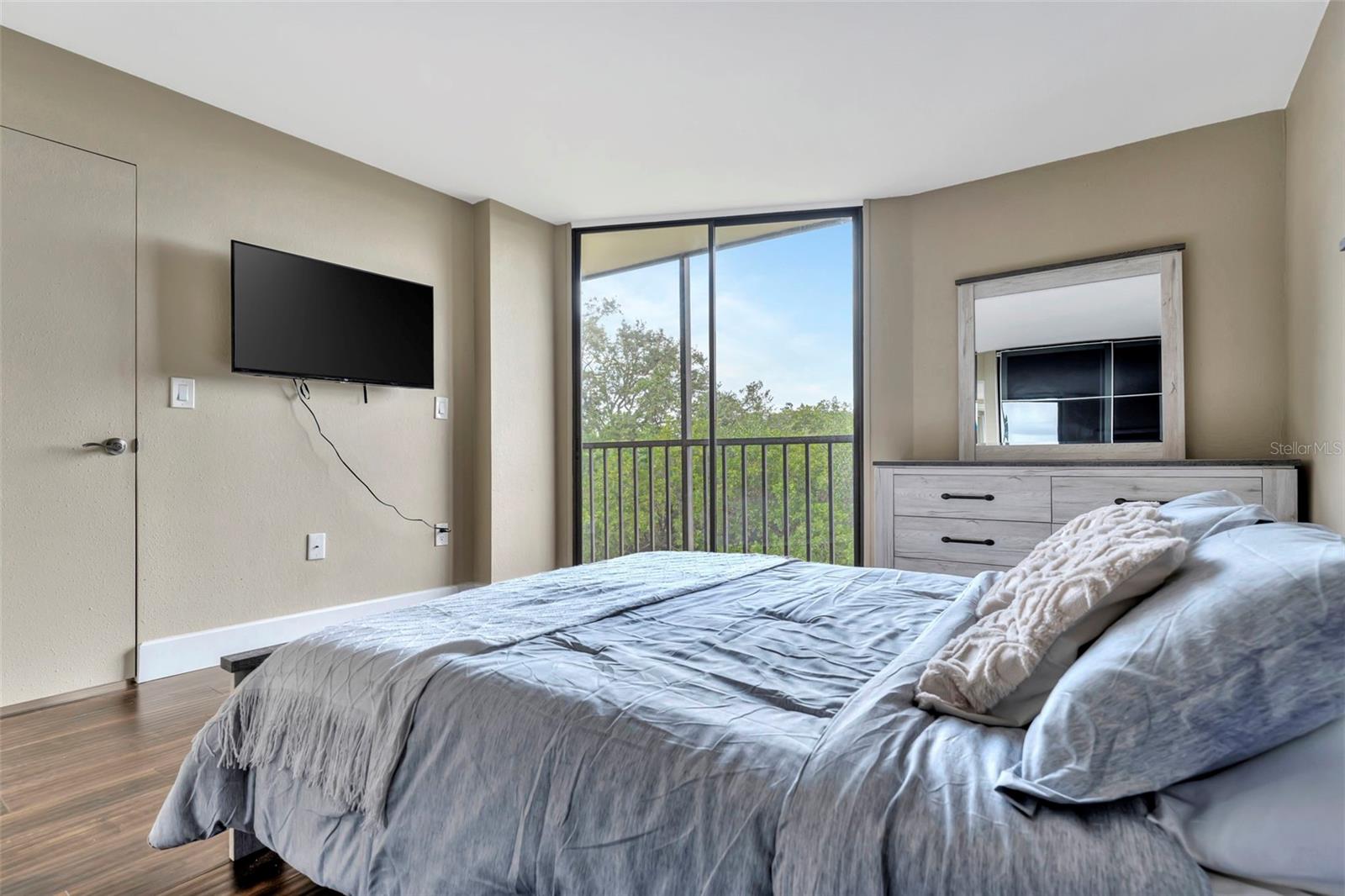 Master bedroom with balcony access and direct sunlight