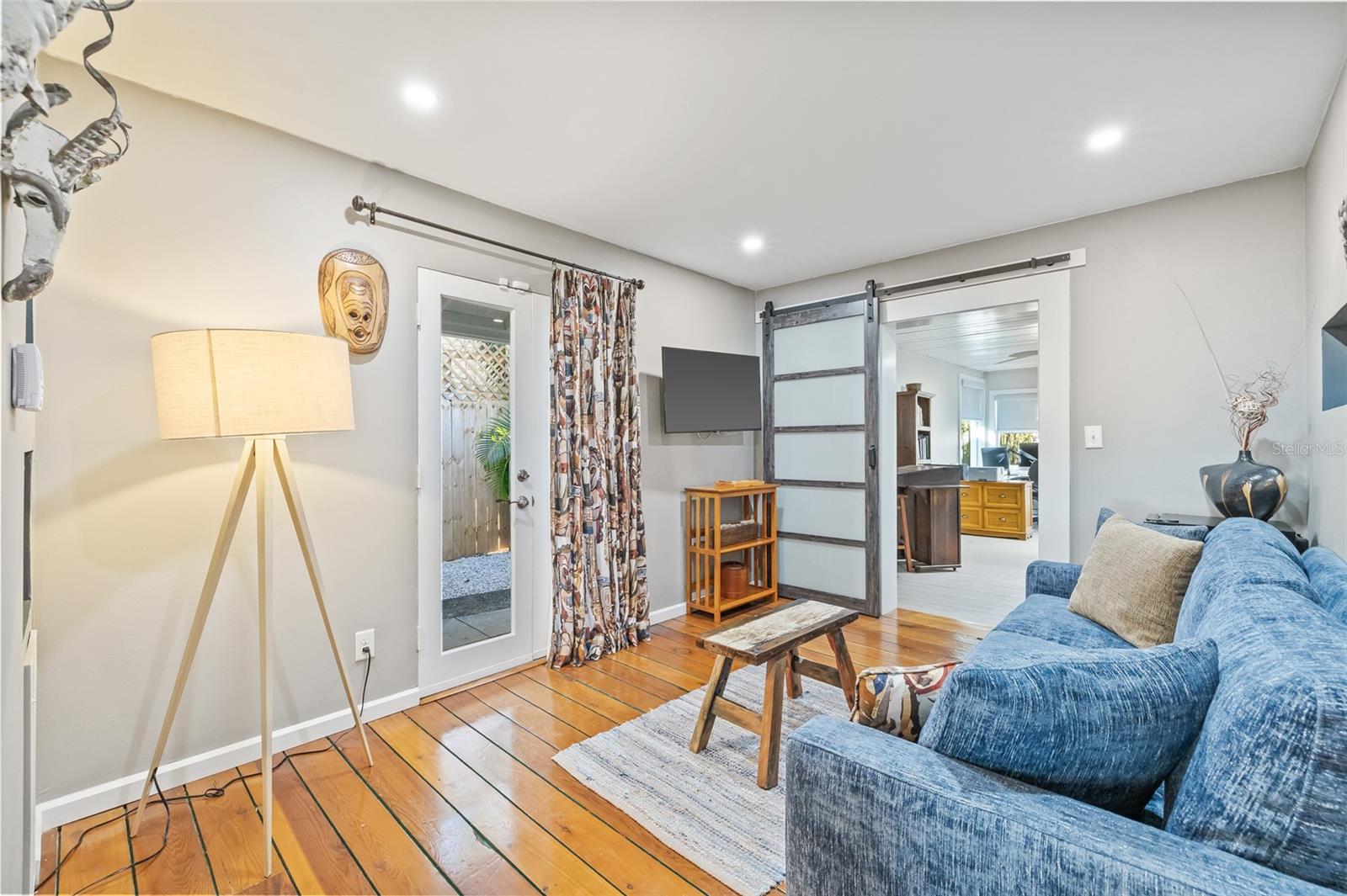 Access to outdoor spaces is available from every room! Notice the beautiful wood flooring and the stunning barn door leading to the 3rd room.