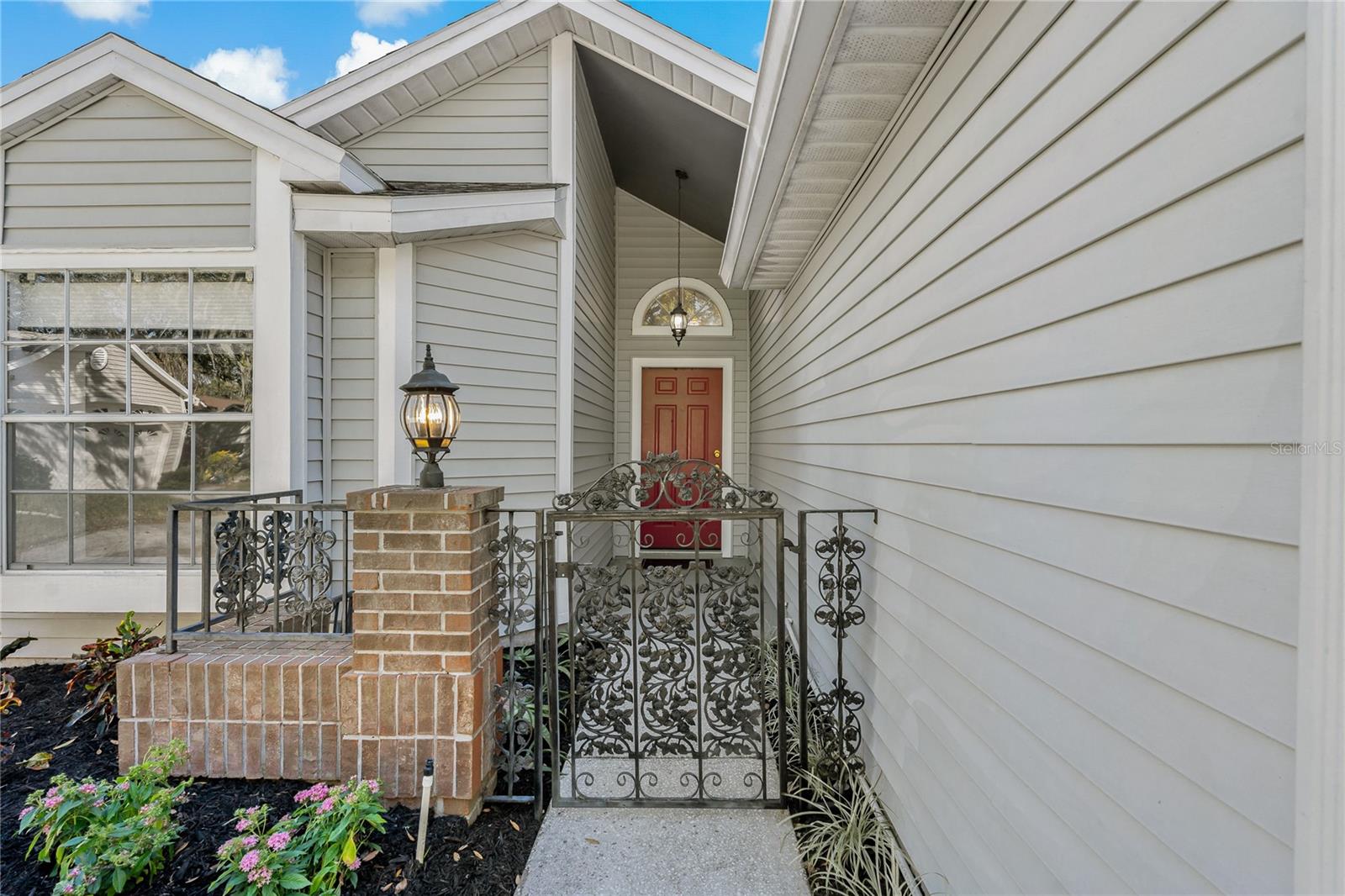 Brick Accents with Decorative Rod Iron near Covered Front Door Entryway