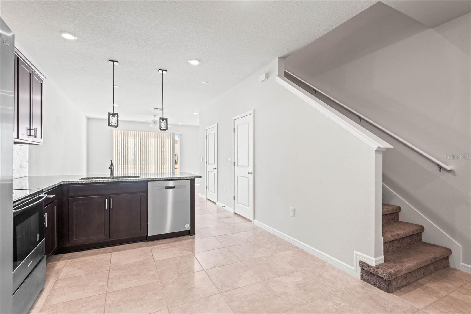 The kitchen has stainless steel appliances, breakfast bar, lighting fixtures, and a ton of storage space both under the stairs & a pantry.