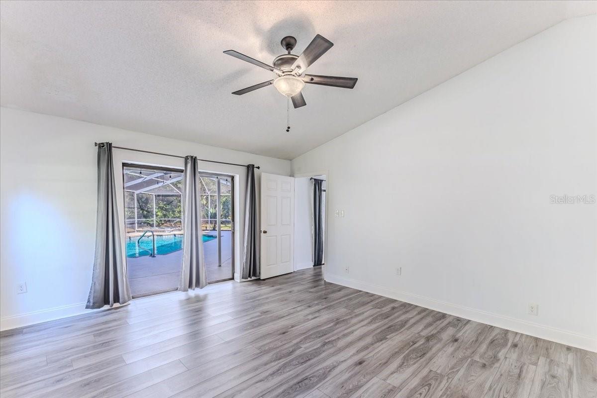 Owner's Primary Bedroom with Sliding Glass Doors going out to the Pool