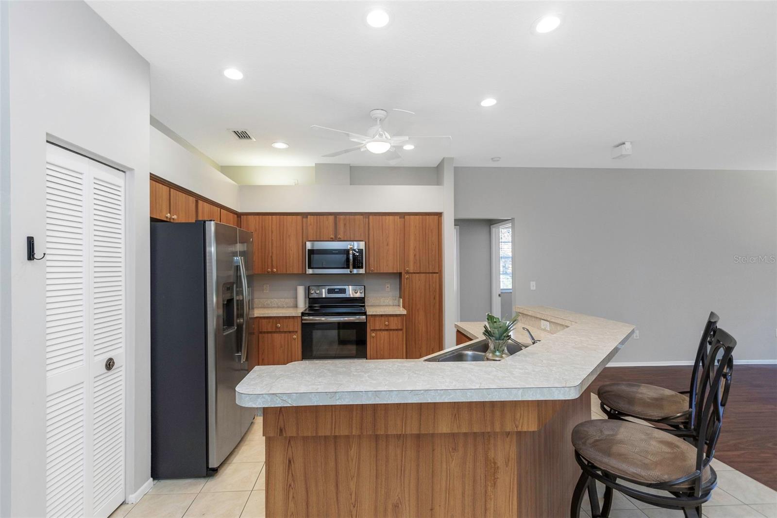 Kitchen complete with GE refrigerator, dishwasher, oven/range, and Frigidaire microwave.