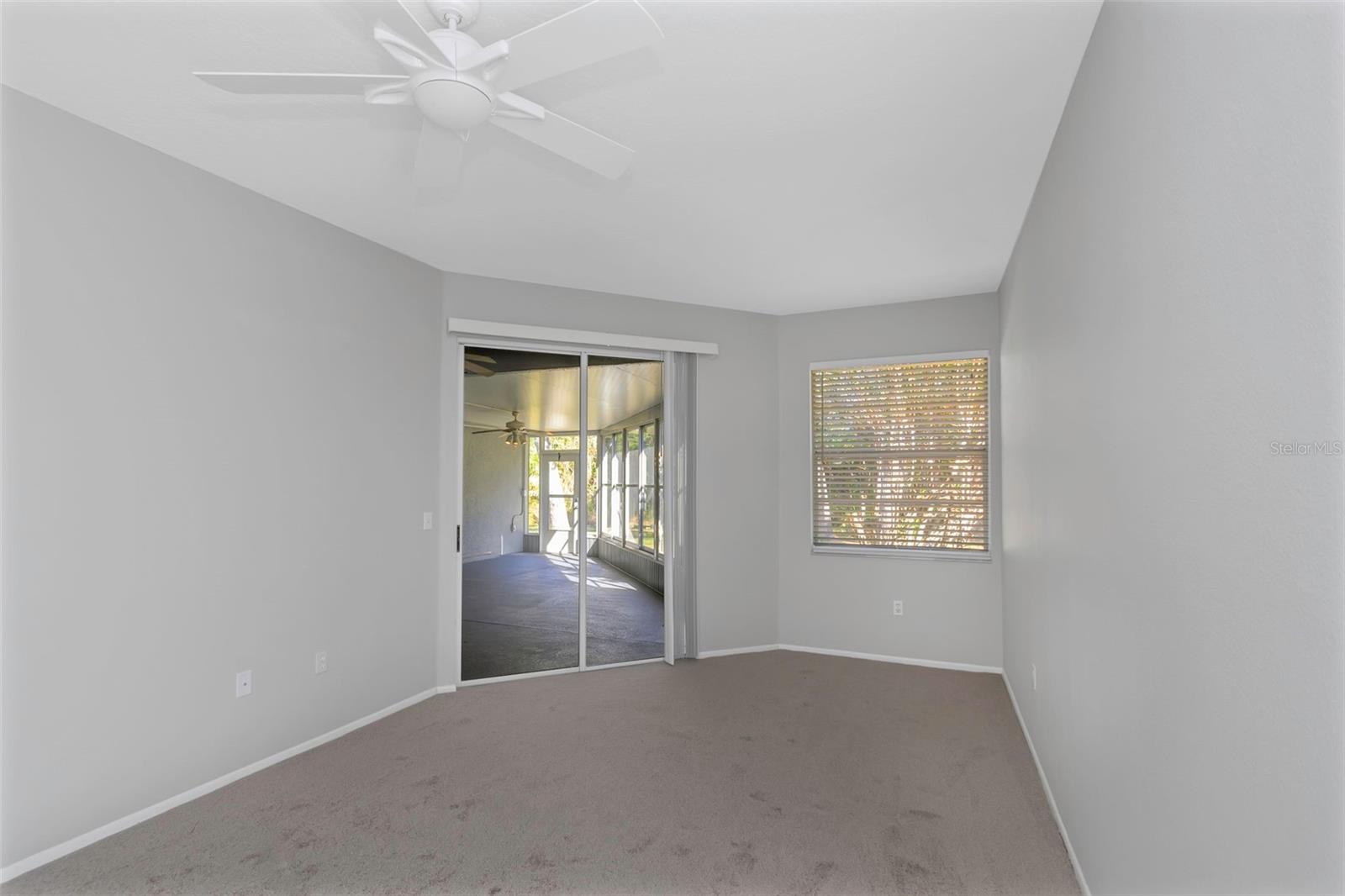 Primary Bedroom with brand new carpeting and sliding door to enclosed lanai.