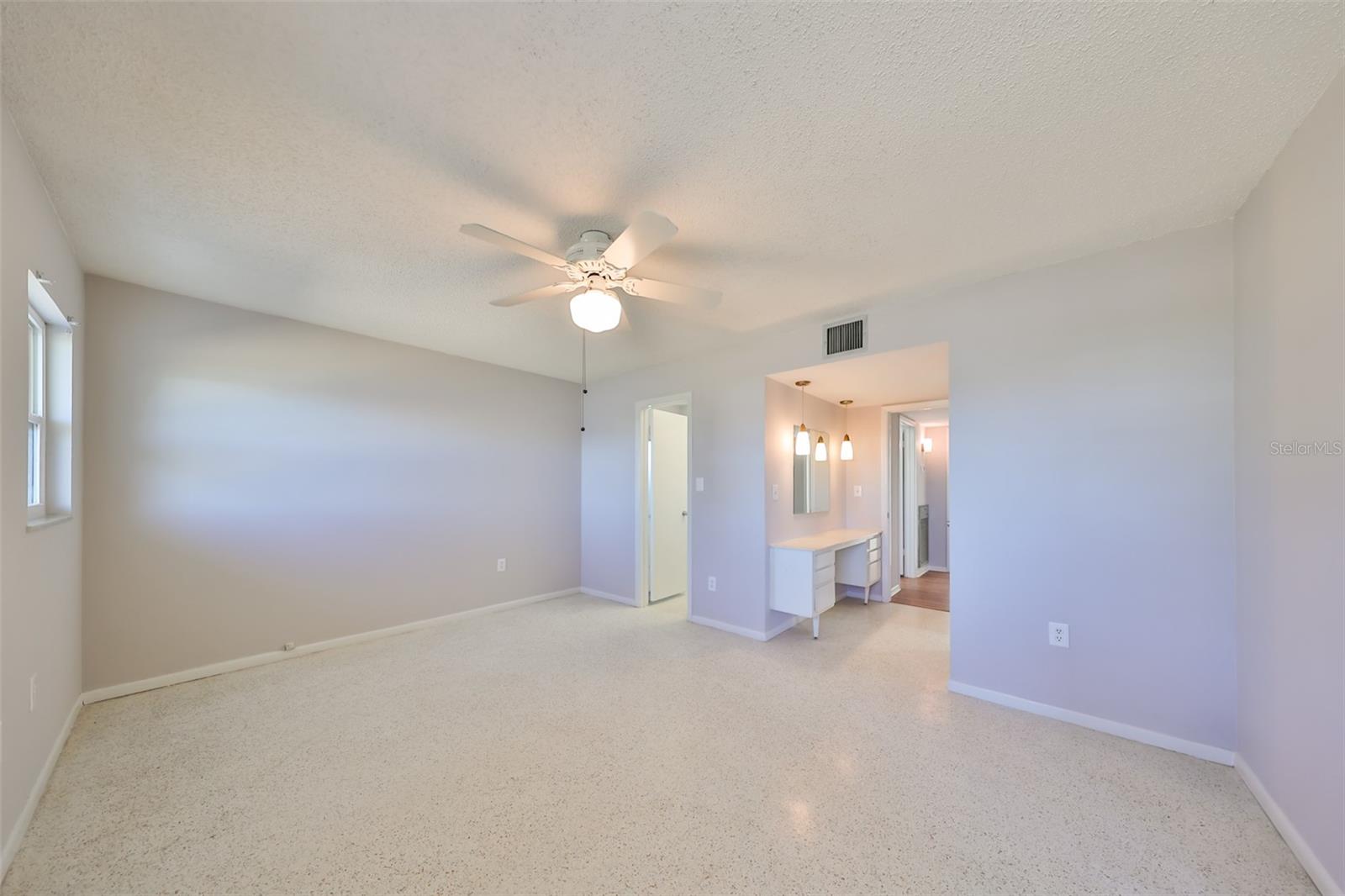 Primary bedroom, view of makeup/vanity area, exit to hall