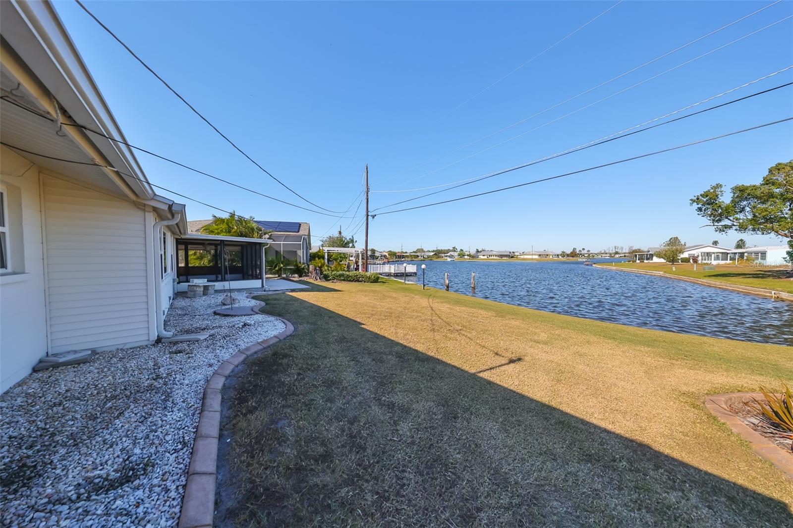 Rear yard, lanai, concrete pad, pilings for mooring, yard to hang out in