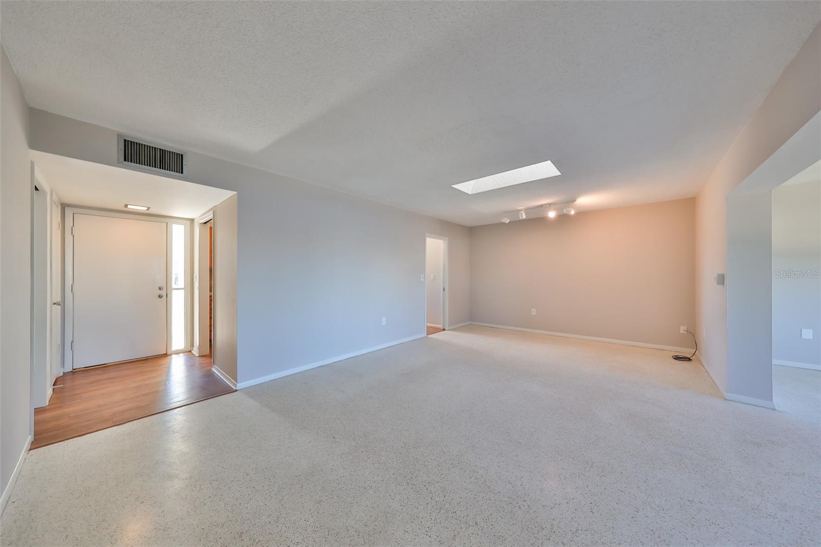 Foyer left, Florida Room far right, dining under track lights, skylight