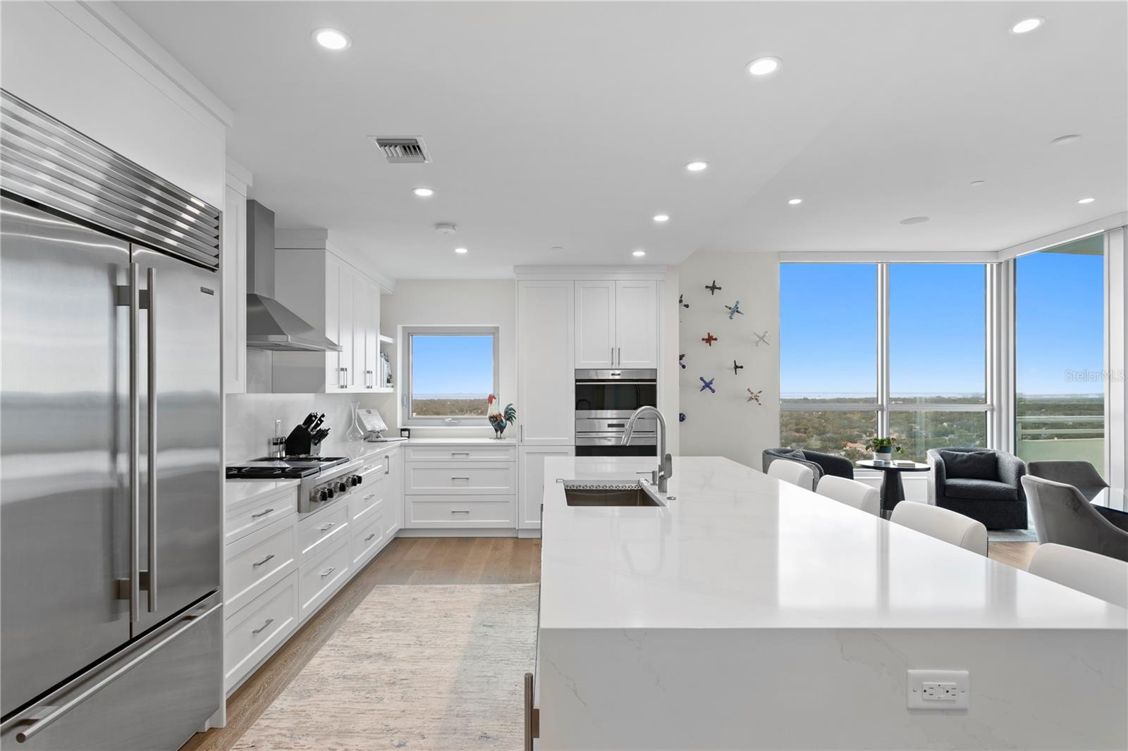 An oversized island with waterfall quartz counters include bar seating and enhanced storage are perfect for extra prep space and hosting gatherings buffet style