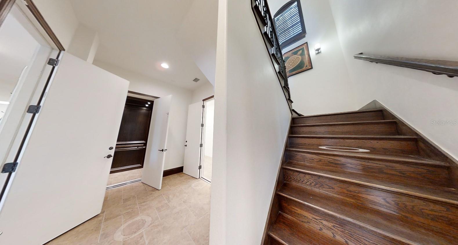 Foyer entry from garage - air conditioned storage room and elevator