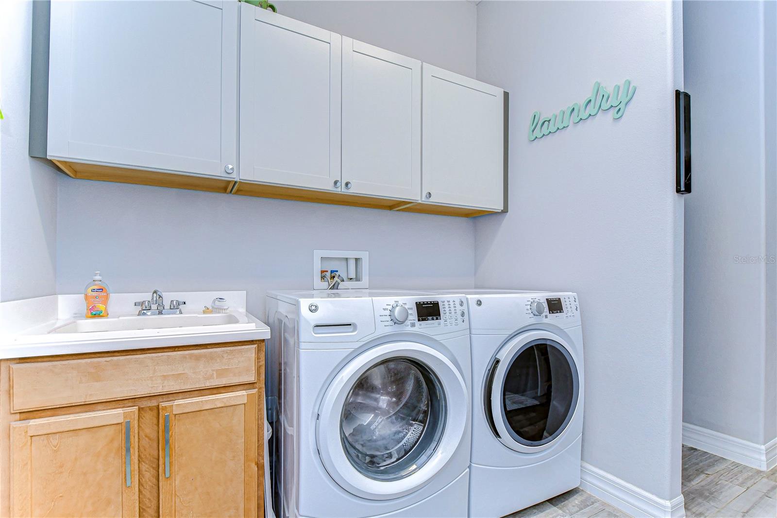 Laundry room with built in soft-close cabinets and sink.