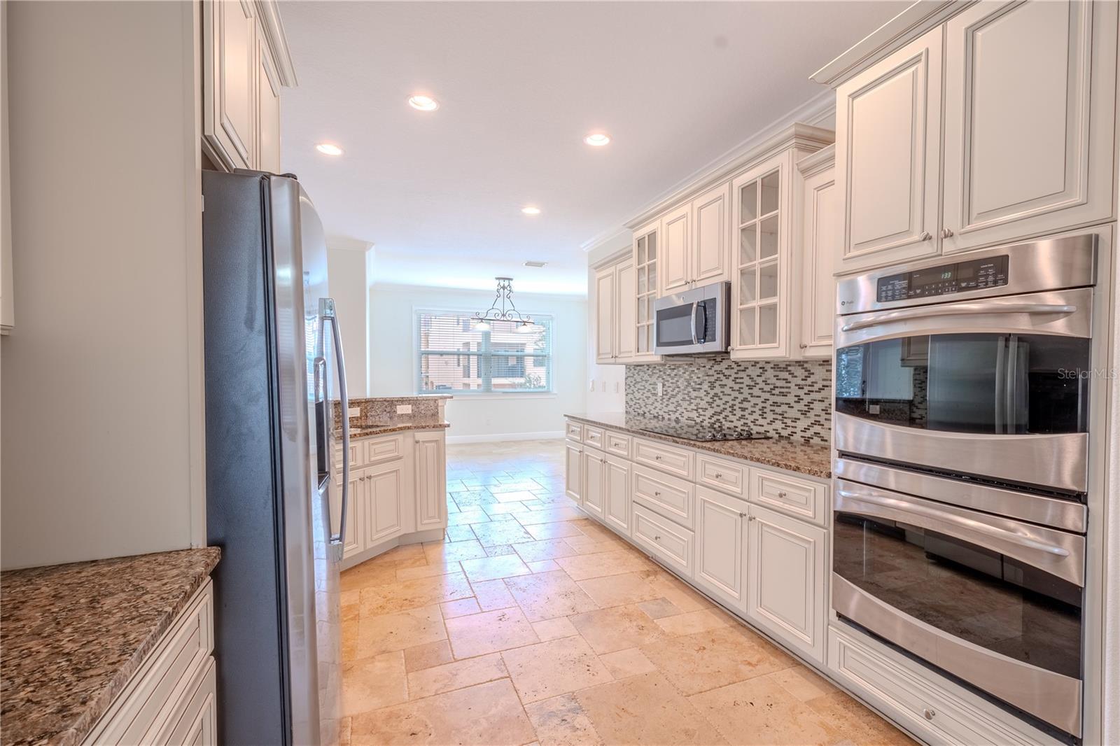 The kitchen features solid wood, soft close cabinets and drawers, granite countertops and a stylish glass tile backsplash.