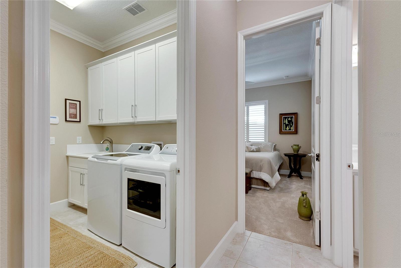 Laundry Room Features a Nice Size Utility Sink and Plenty of Cabinets for Storage