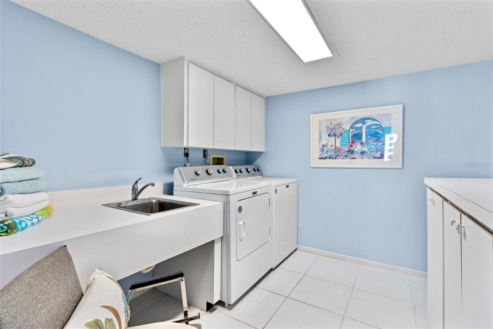 INTERIOR LAUNDRY ROOM with utility sink and plenty of built in cabinetry is huge and located perfectly, just across hall from Primary Bedroom