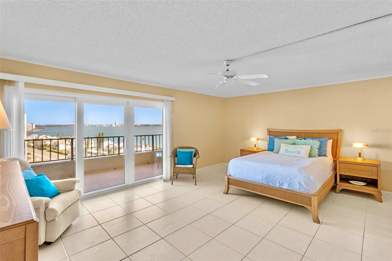 Primary bedroom suite with water views through sliding doors that open to balcony.