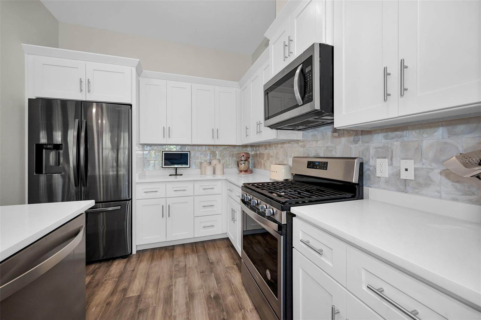 Stainless appliances and gorgeous cabinets.