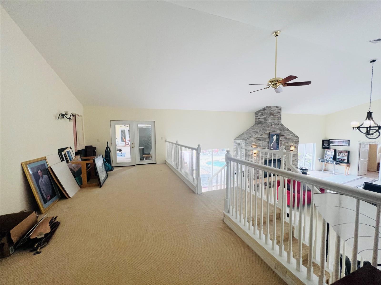 INDOOR UPPER AREA DOUBLE DOORS LEAD TO OUTSIDE LIVING AREA AND SLIDERS AND MAIN HOUSE