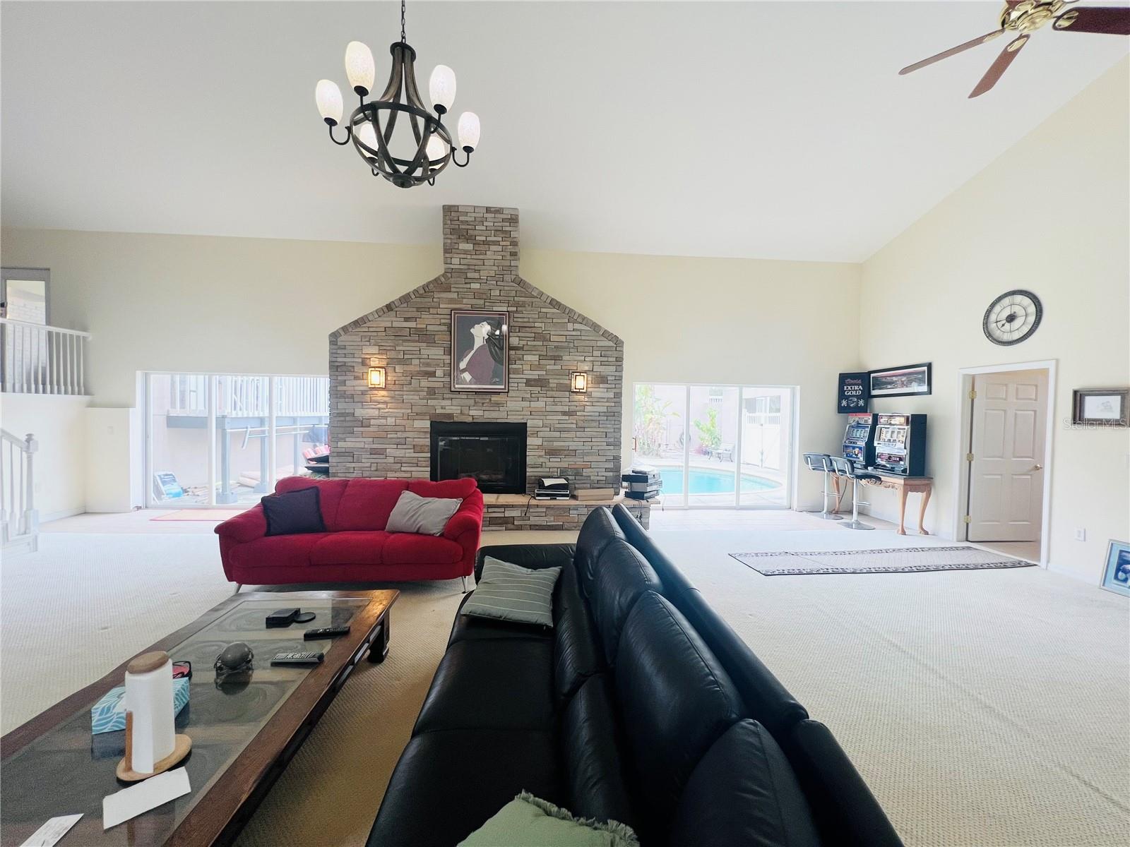 VIEW OF FIRE PLACE AND SLIDERS THAT LEAD TO COURT YARD BATHROOM TO RIGHT WET BAR TO RIGHT