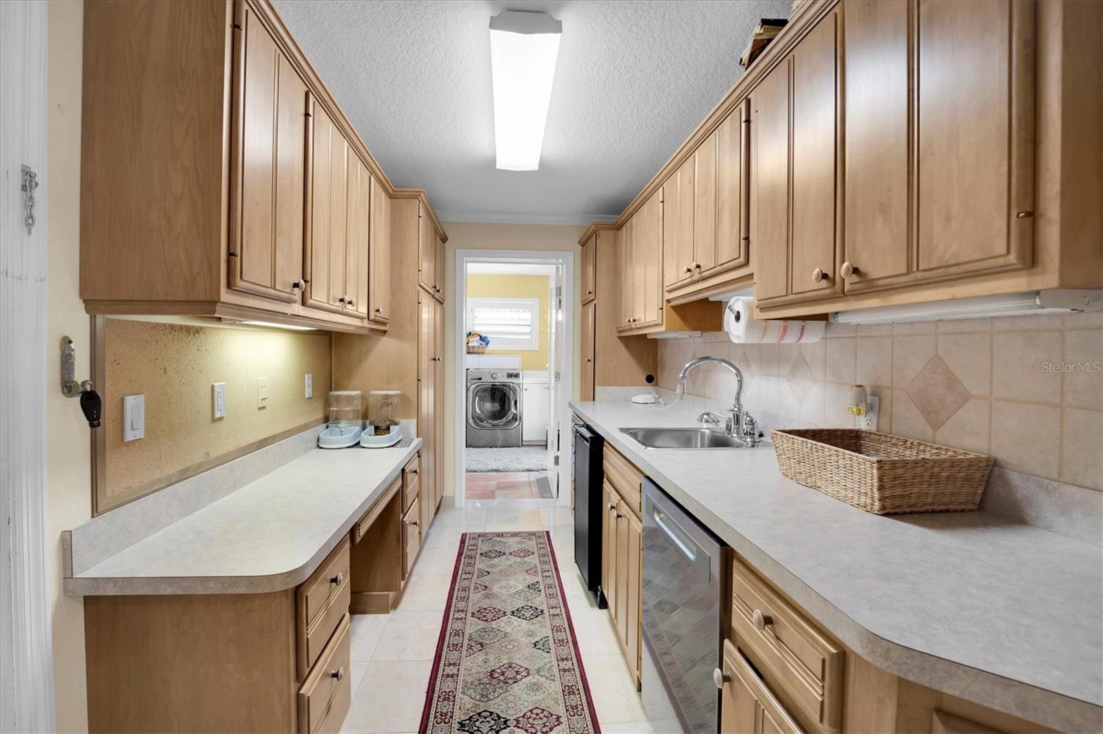 Butler pantry with full sink and garbage disposal, dishwasher and tons of storage