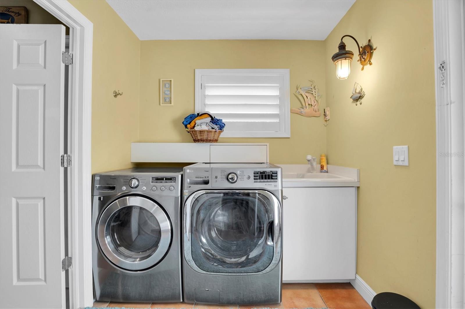 Laundry room with exterior door, basin sink with garbage disposal and ceramic tile