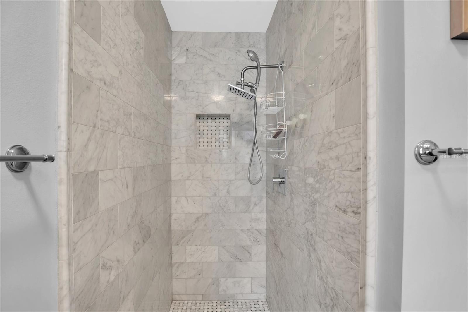 Custom marble walk in shower in primary bedroom suite