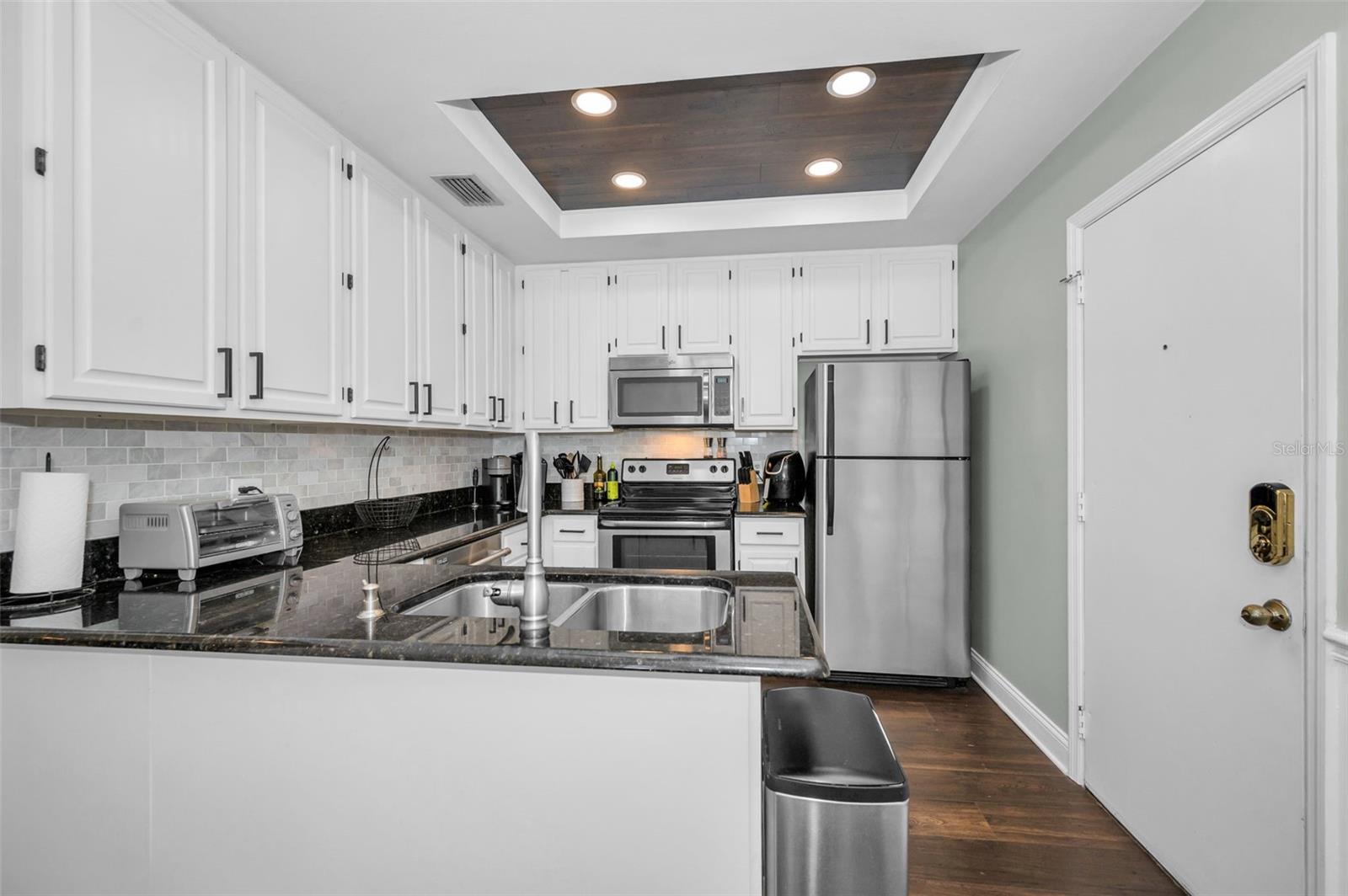 Perfect kitchen with wood cabinets, stainless appliances, granite counters and wood floors