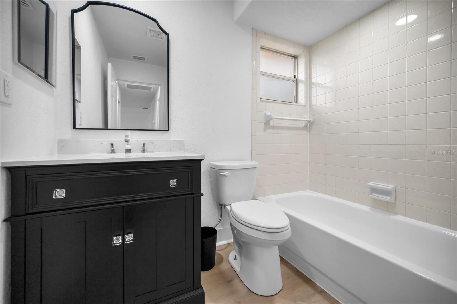 Bathroom 2 Boasting Tasteful Vanity with Marble Sink and Countertop and Tub/Shower