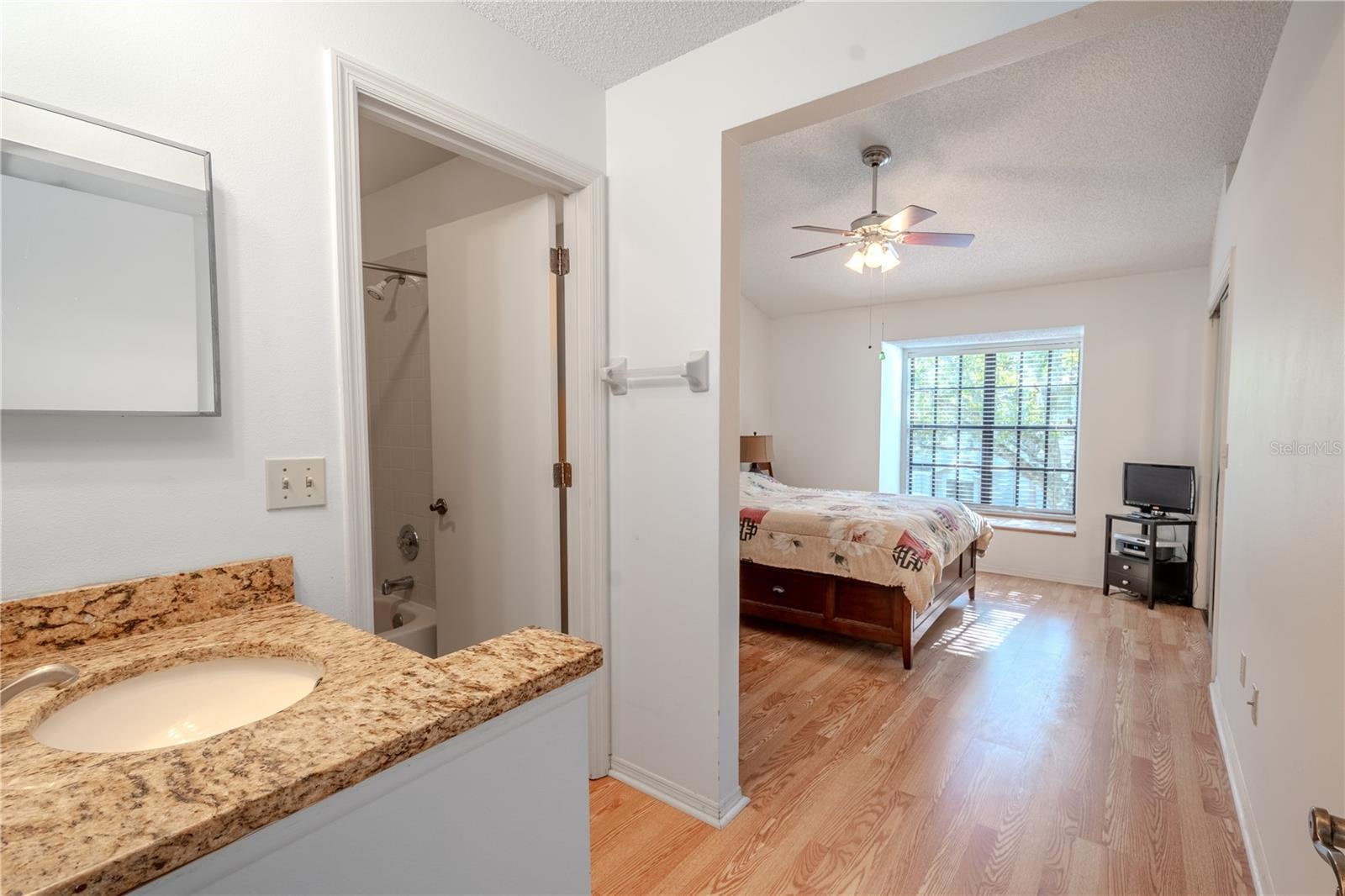 The Primary bedroom (an ensuite) has wood laminate flooring, a vaulted ceiling with ceiling fan and light kit and a walk-in closet.